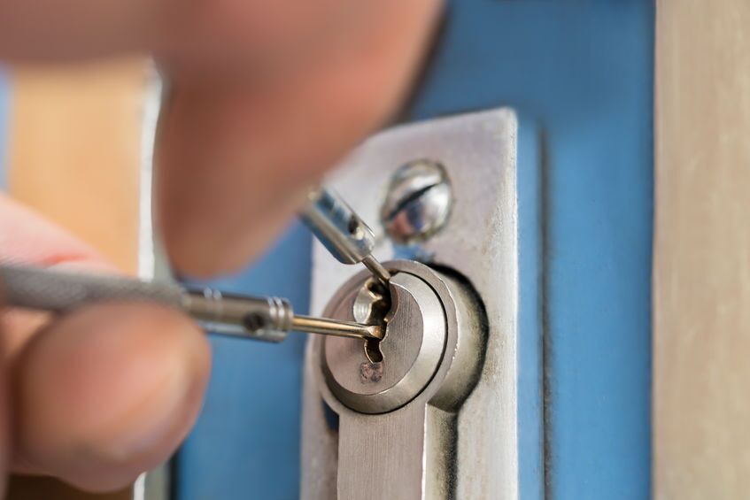 Lockpicker Fixing Door Handle At Home commercial locksmith picking lock on the exterior door of a building in danville